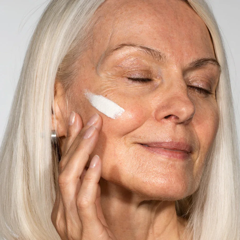 La crème sort blanche sur la joue, avant d'être estompée